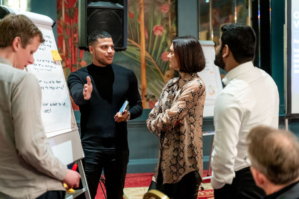Image of people standing around a flipchart discussing core values.