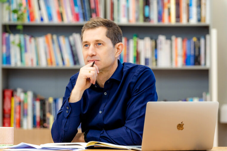 Ben Morton sitting at laptop, thinking.